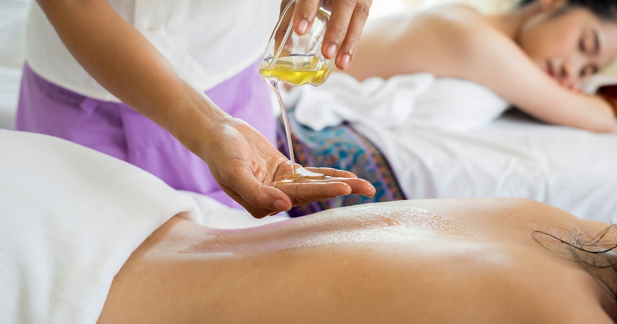 Relaxing spa setup with essential oils, heated towels, and skincare products