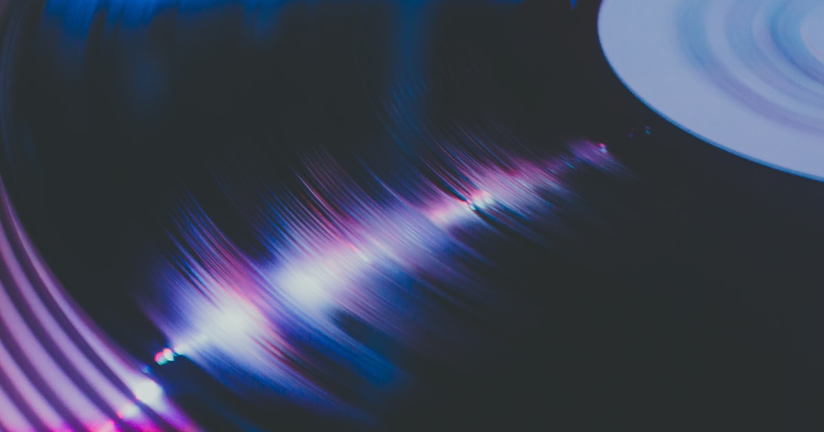 A modern turntable setup with vinyl records displayed on a clean wooden surface